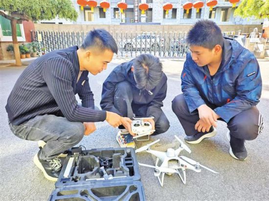 10月22日,在陜西工程科技高級技工學校,楊帆(左)指導學生操控無人機。